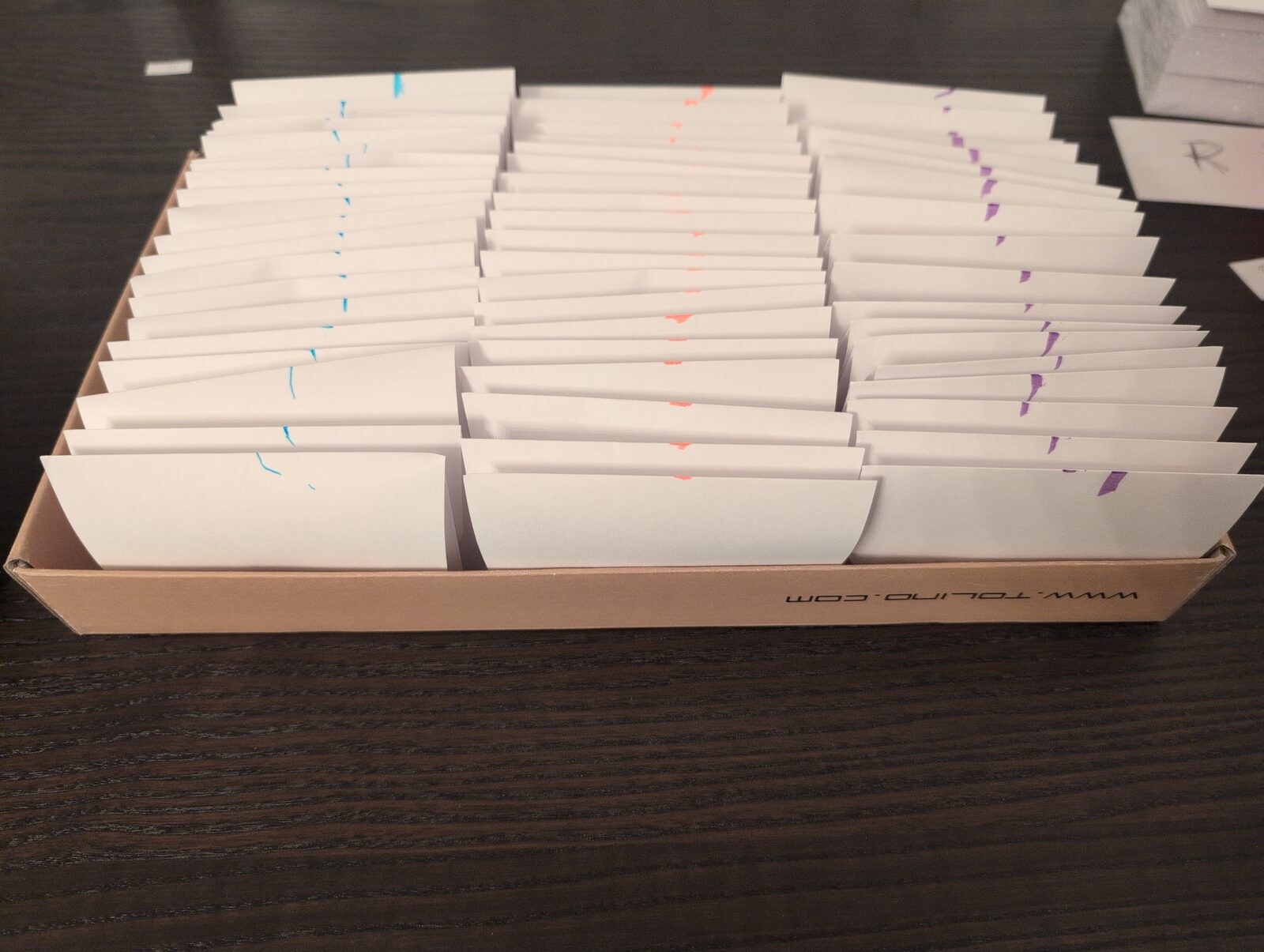 3 stacks of envelopes, each stack marked with a different color